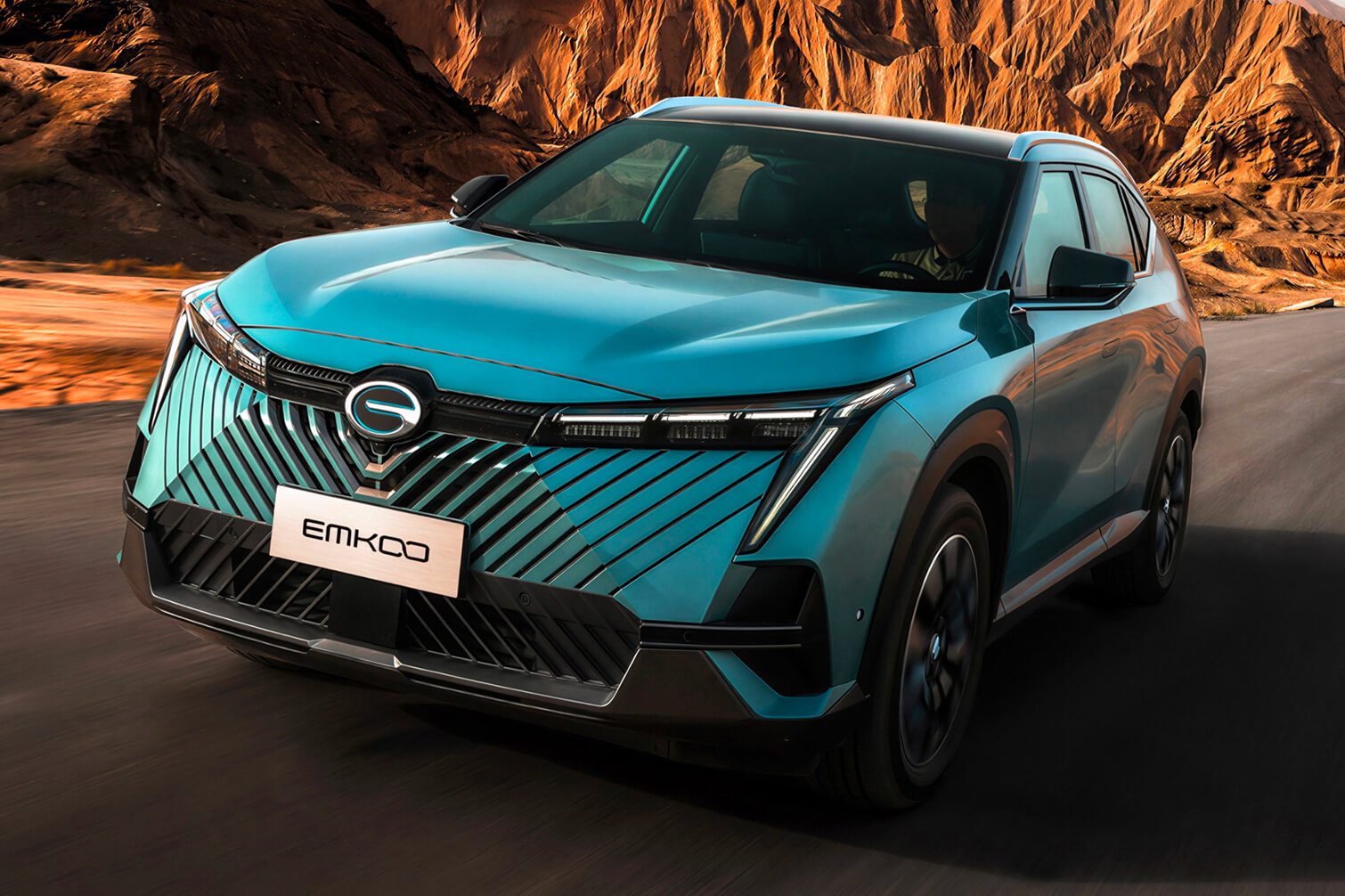Samochód GAC EMKOO hybrydowy SUV klasy D w trakcie jazdy na tle gór - wnętrze i design modelu z układem 235 KM